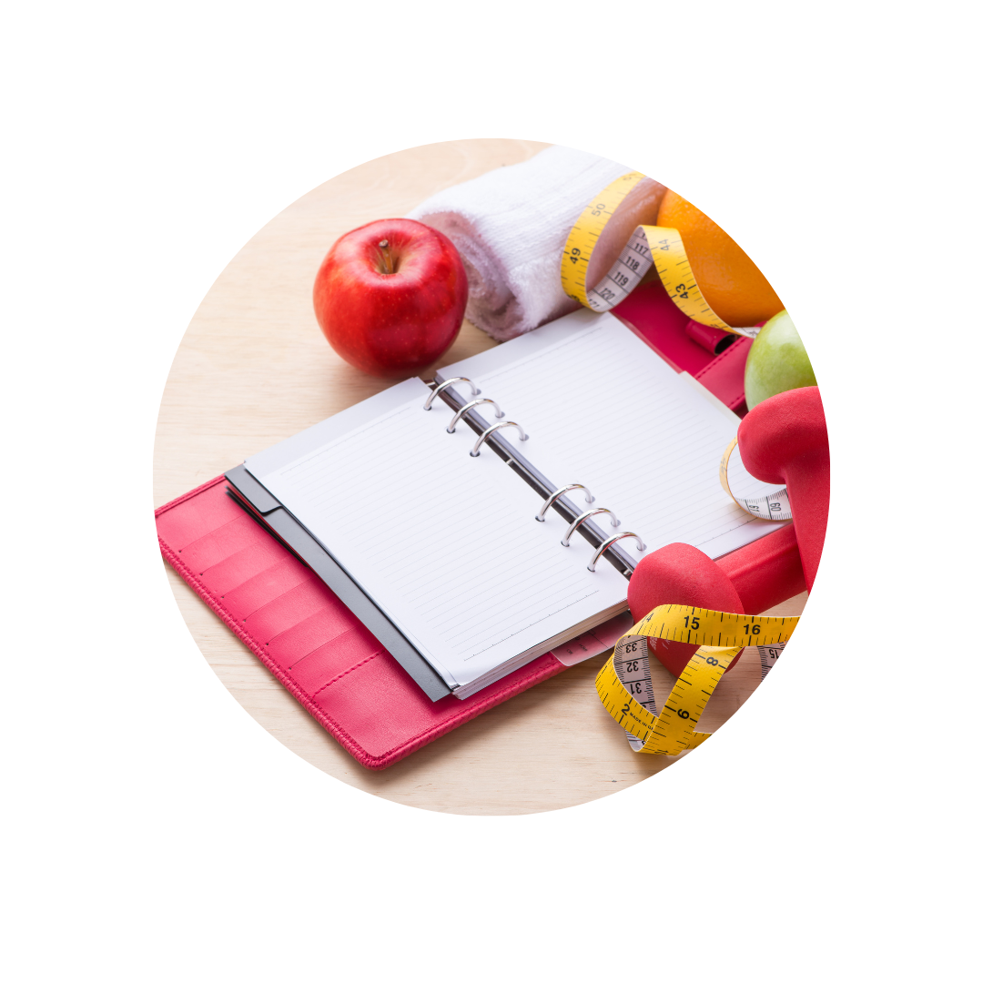 Caderno aberto com as folhas em branco e maçãs, laranjas e halter rosa de borracha ao redor