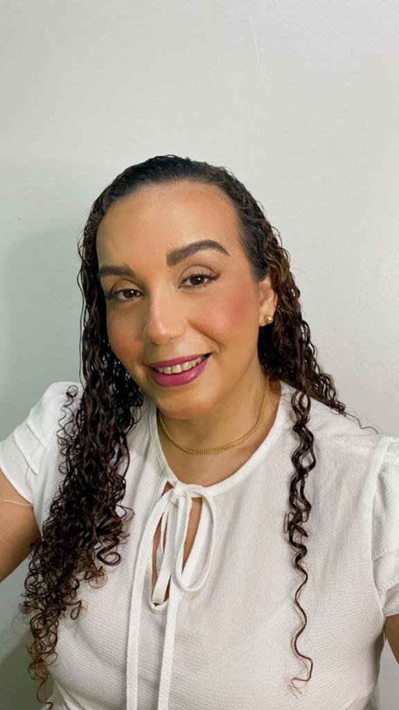 Nutricionista Daniely Santos em seu consultório em sua mesa tem um notebook branco.